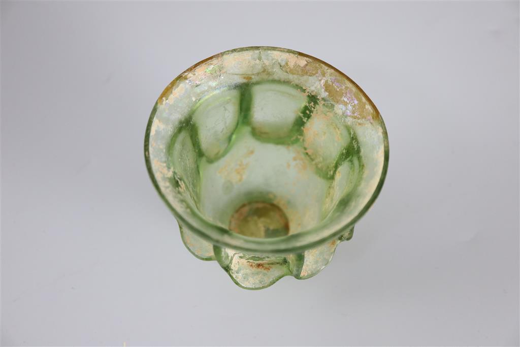 A Roman green glass auricular cup, 2nd/3rd century AD, 7.5cm high